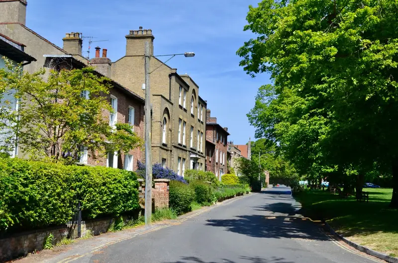 A tree-lined residential street with brick houses