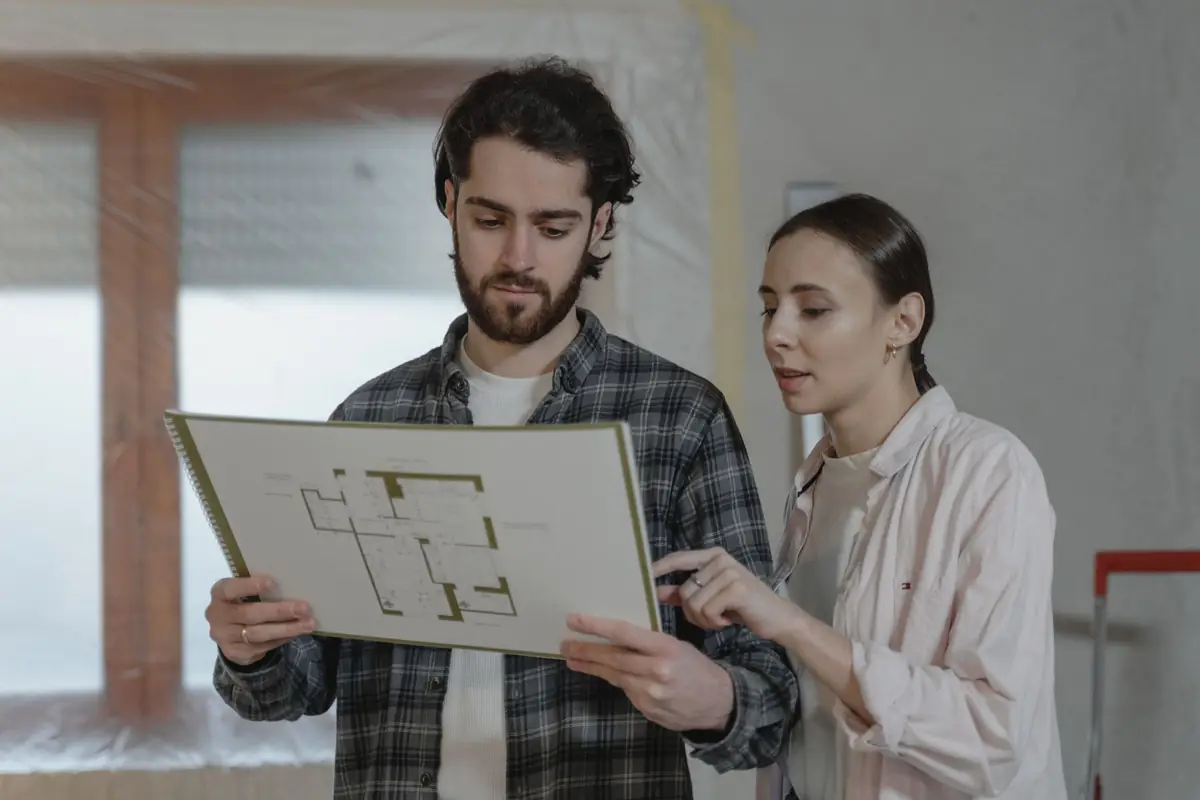 A couple going over the floor plan for their garage conversion.